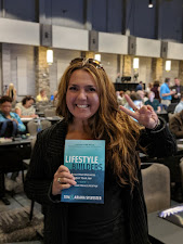 A reader holding a copy of Lifestyle Builders at an event